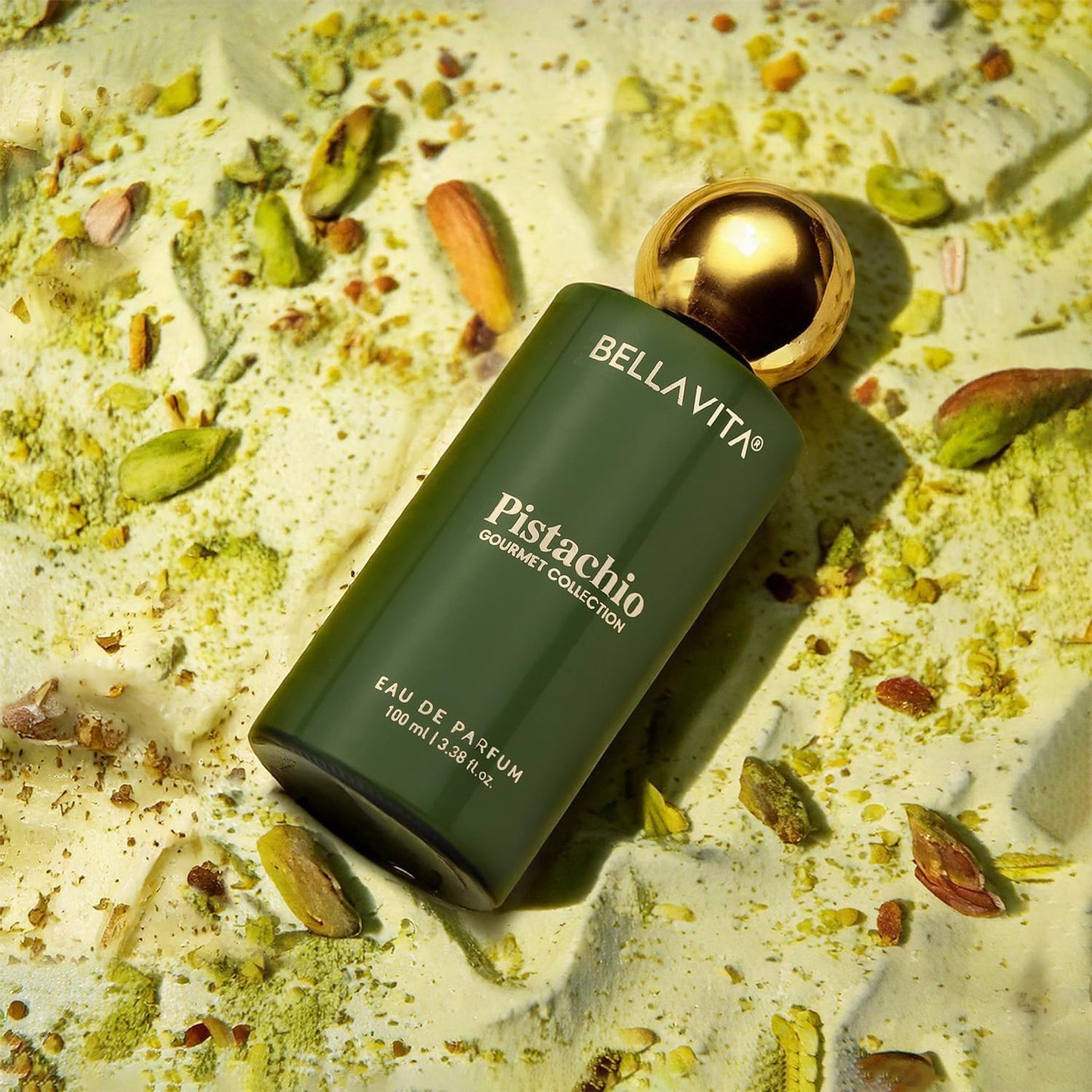 Green Bellavita Pistachio perfume bottle on a textured surface with pistachios.