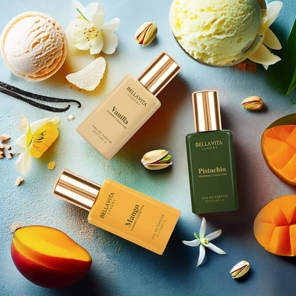 Three BellaVita perfume bottles with vanilla, pistachio, and mango scents on a blue background with flowers and fruits.