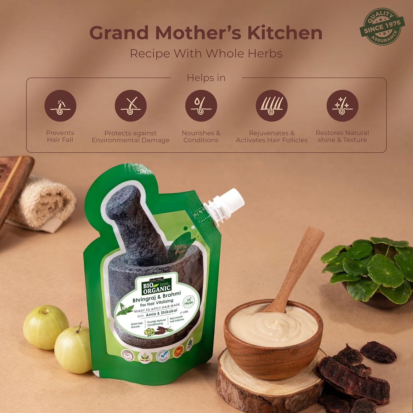 Green packaging of a hair care product with herbs and apples on a wooden surface, labeled 'Grand Mother's Kitchen'.