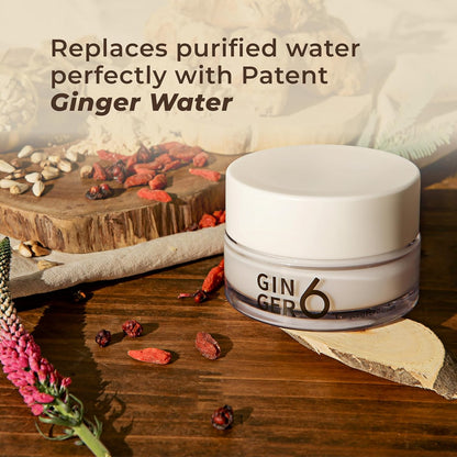 Jar of 'GIN GER6' on a wooden surface with dried ginger and flowers.