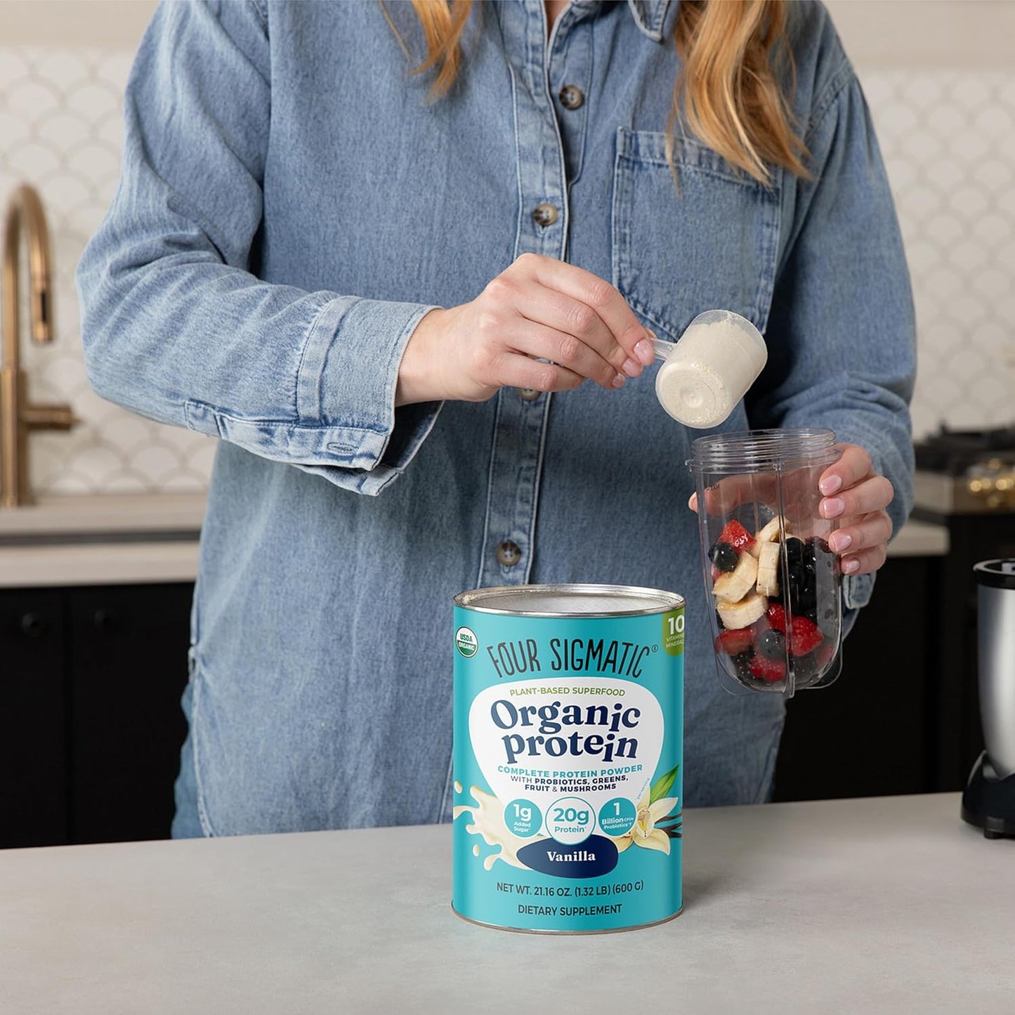 Person preparing a protein shake with Four Sigmatic Organic Protein can in the foreground.