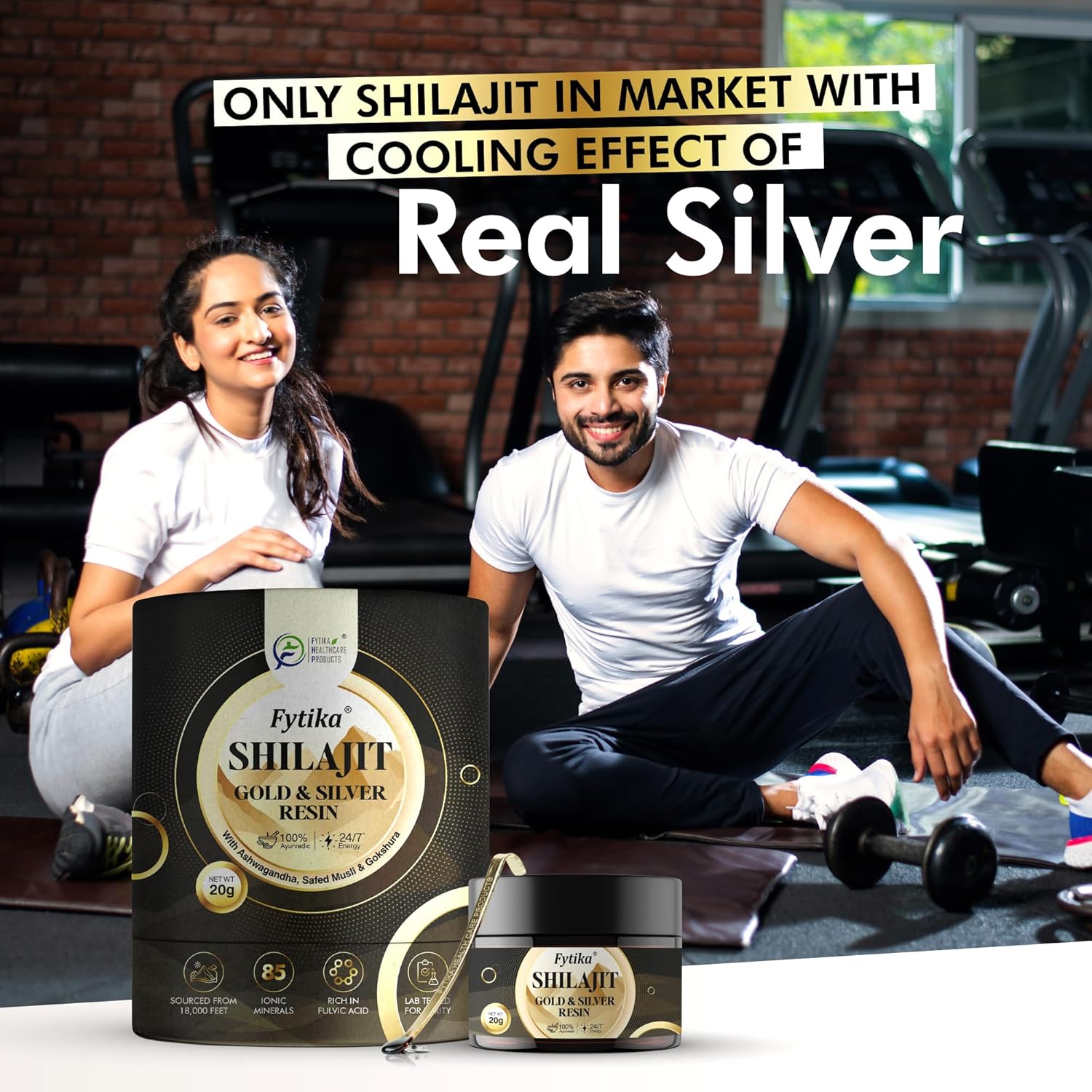 Two people sitting on a gym floor with Fytika Shilajit Gold & Silver Resin packaging in front of them.