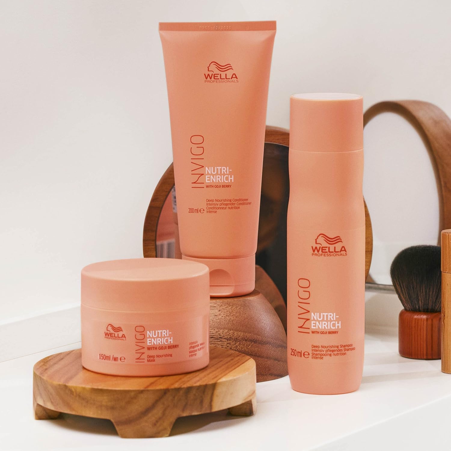 Wella Invigo hair care products on a wooden stand with a neutral background
