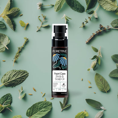 PURETIVE Psori Care Body & Scalp Oil bottle surrounded by green leaves on a light green background