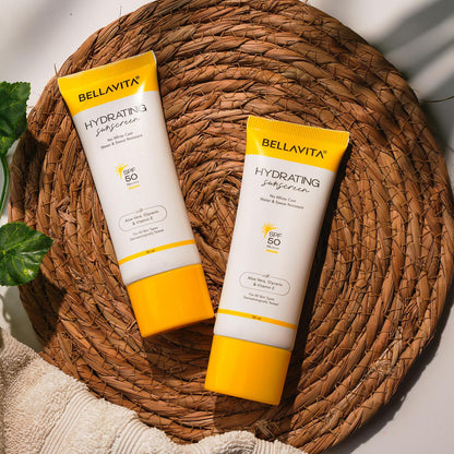 Two bottles of Bellavita hydrating sunscreens on a woven mat.