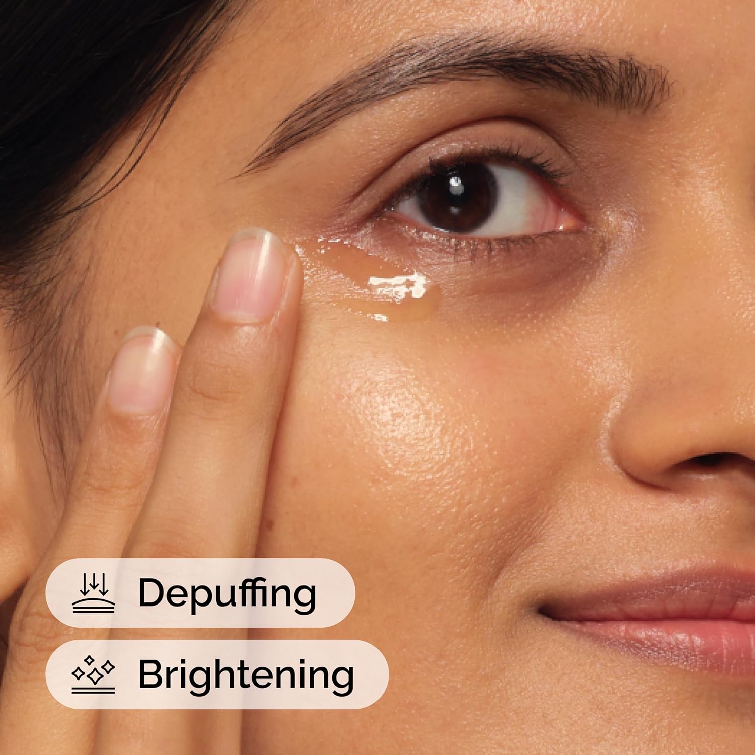 Close-up of a woman applying cream under her eye with text 'Depuffing' and 'Brightening'.