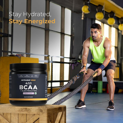 Person using resistance ropes with a supplement container labeled 'NutraBay Gold BCAA' in a gym setting.