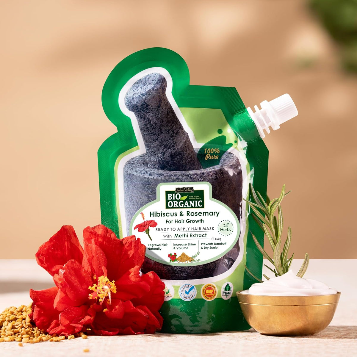 Green organic product packaging with hibiscus and rosemary, featuring a red flower and a bowl of white powder on a beige background.