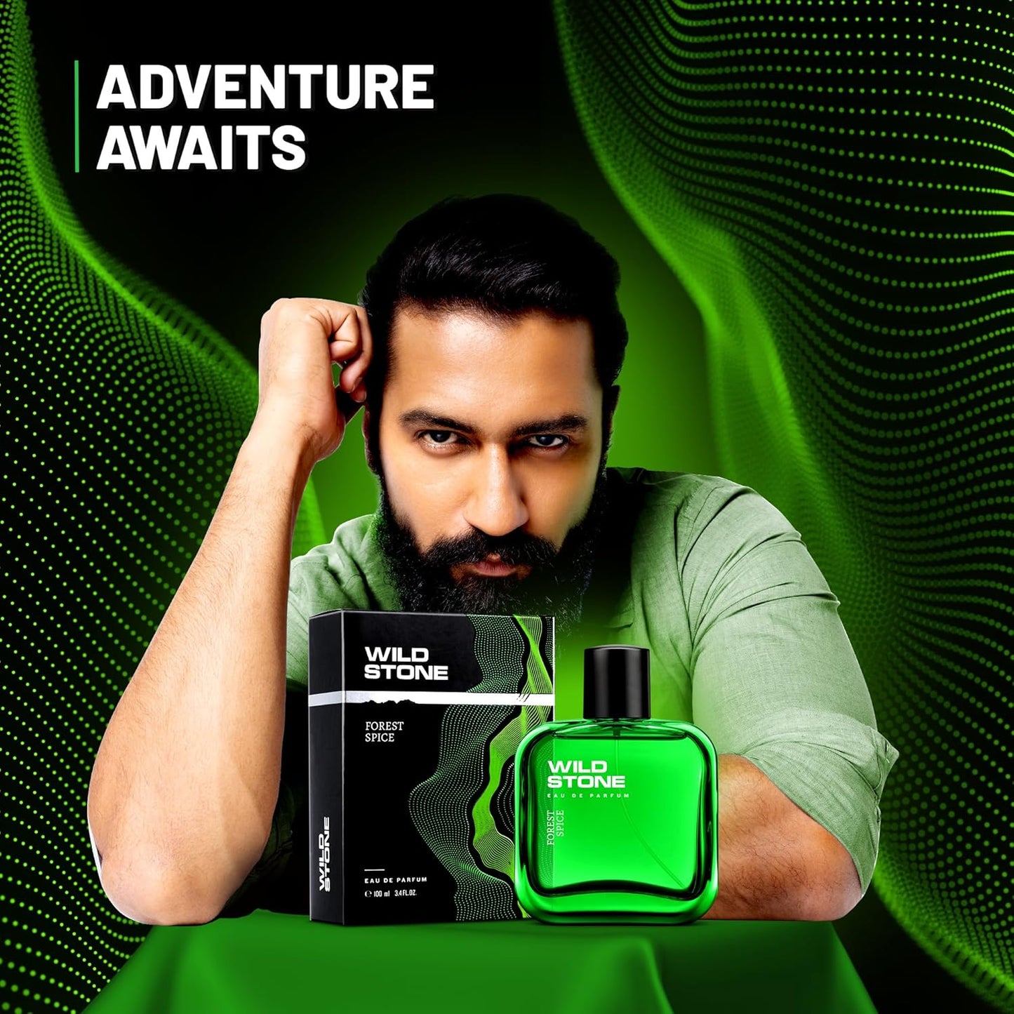 Man holding Wild Stone perfume bottle and packaging against a green background with 'Adventure Awaits' text.