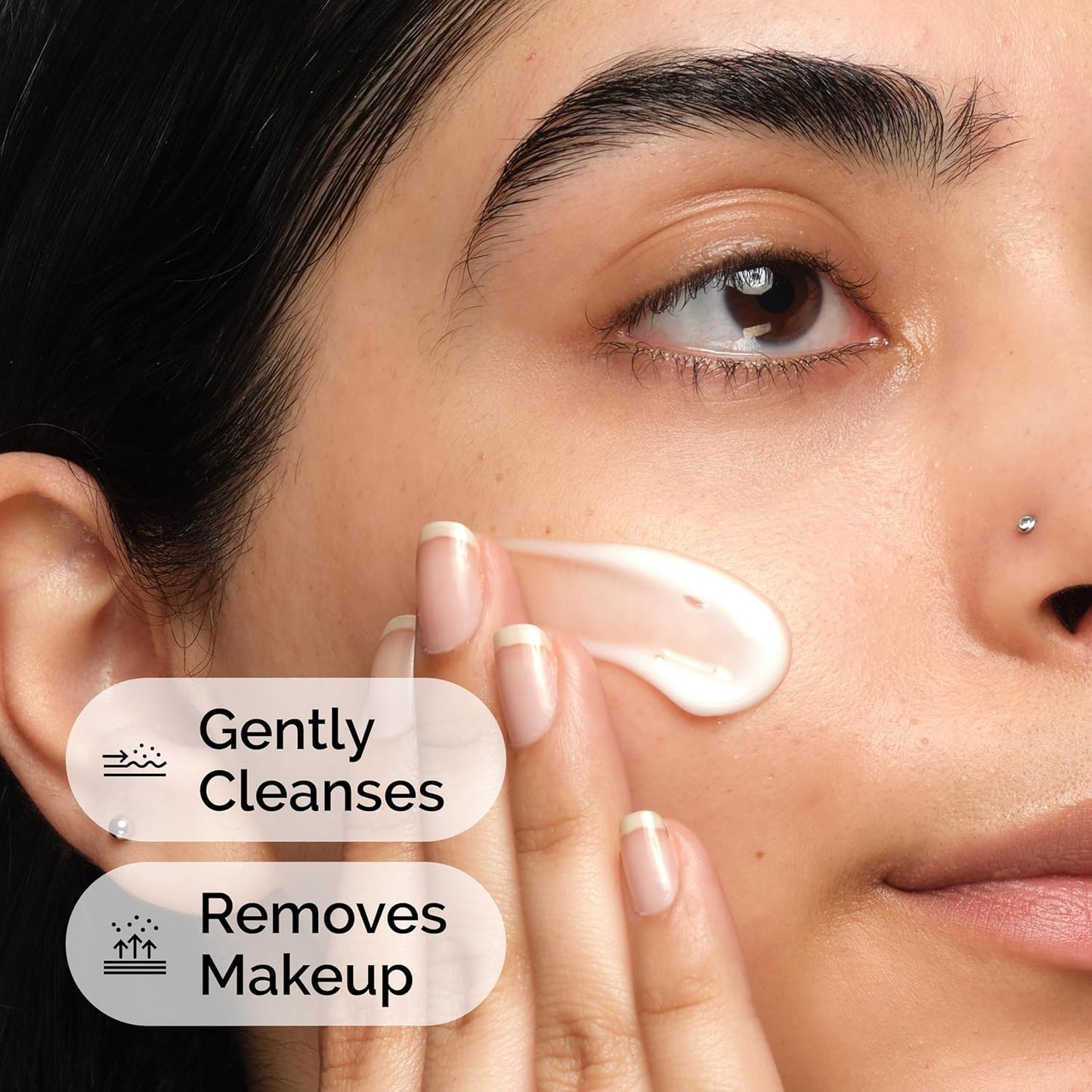 Person applying a skincare product to their face with text indicating cleansing and makeup removal.