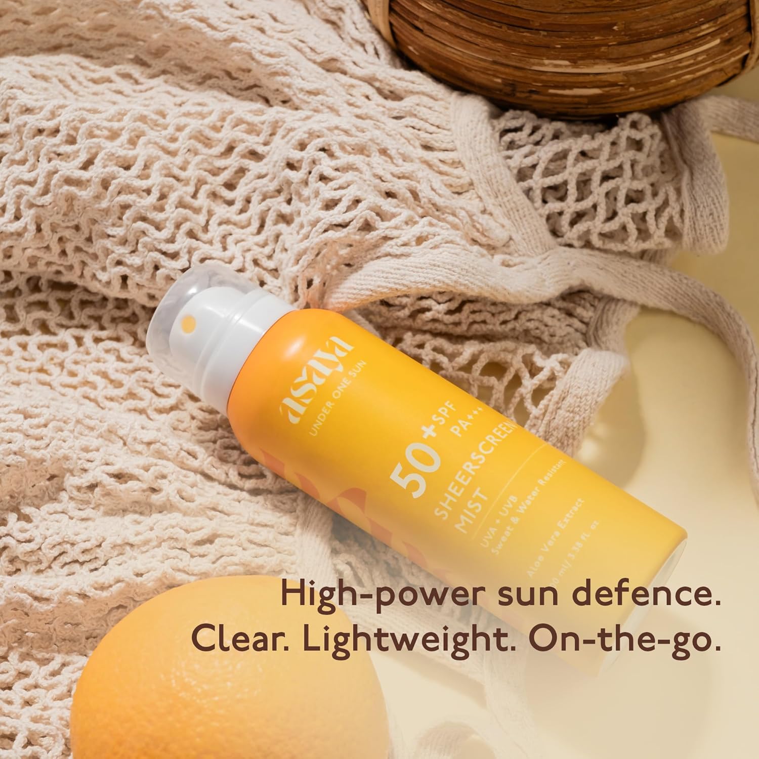 Sunscreen spray bottle with text on a textured fabric background