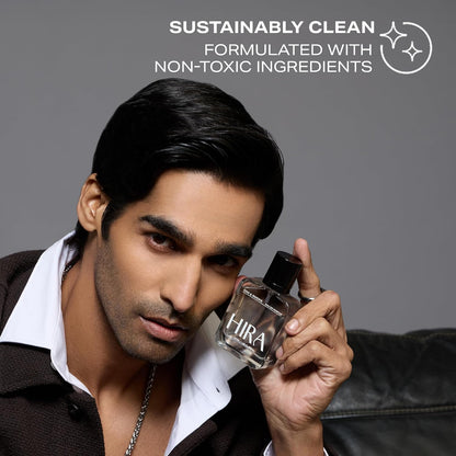 Man holding a perfume bottle with 'Sustainably Clean' text and logo on a gray background