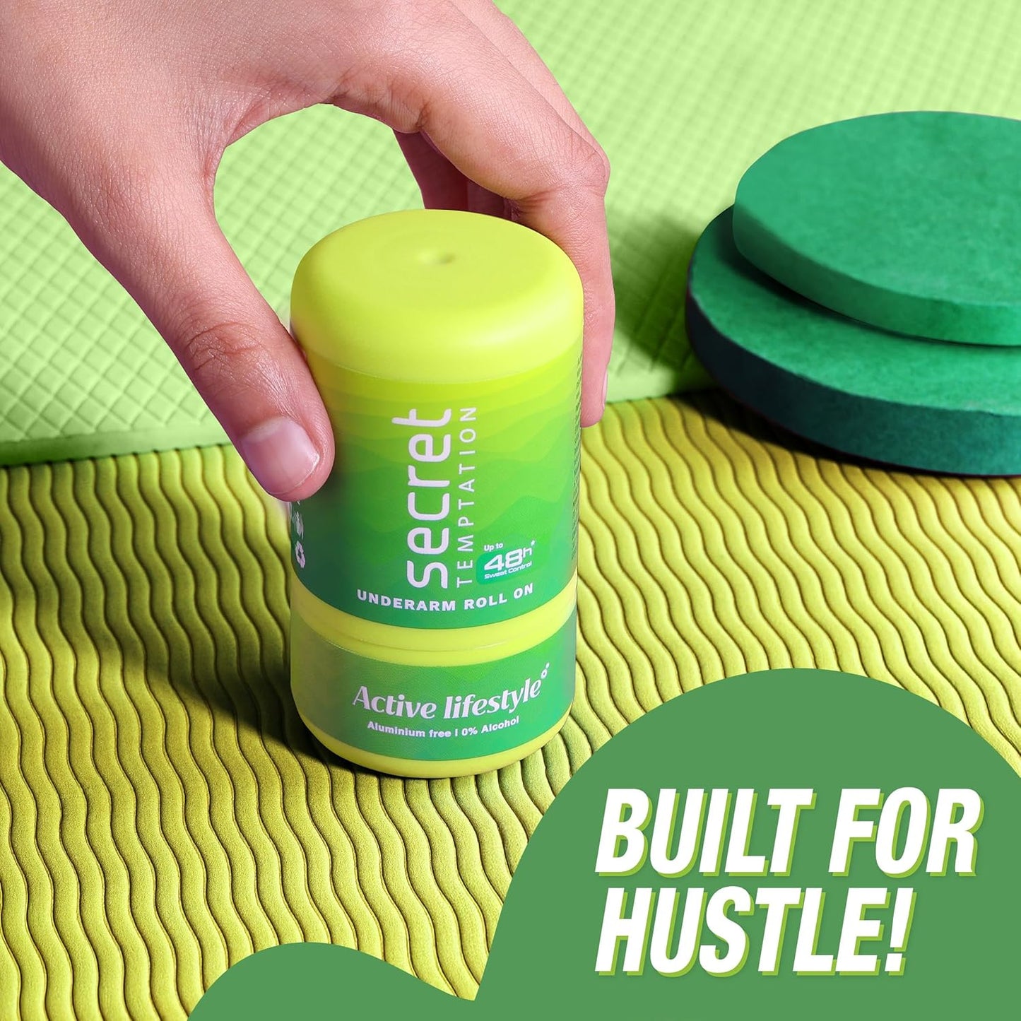Hand holding a green and yellow roll-on deodorant with text on a textured green surface.