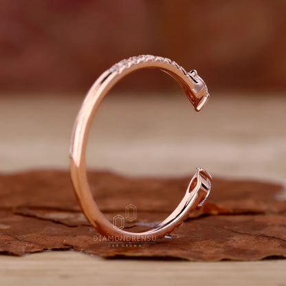 Rose gold ring with diamond accents on a brown surface, brand 'Diamondrensu' visible.