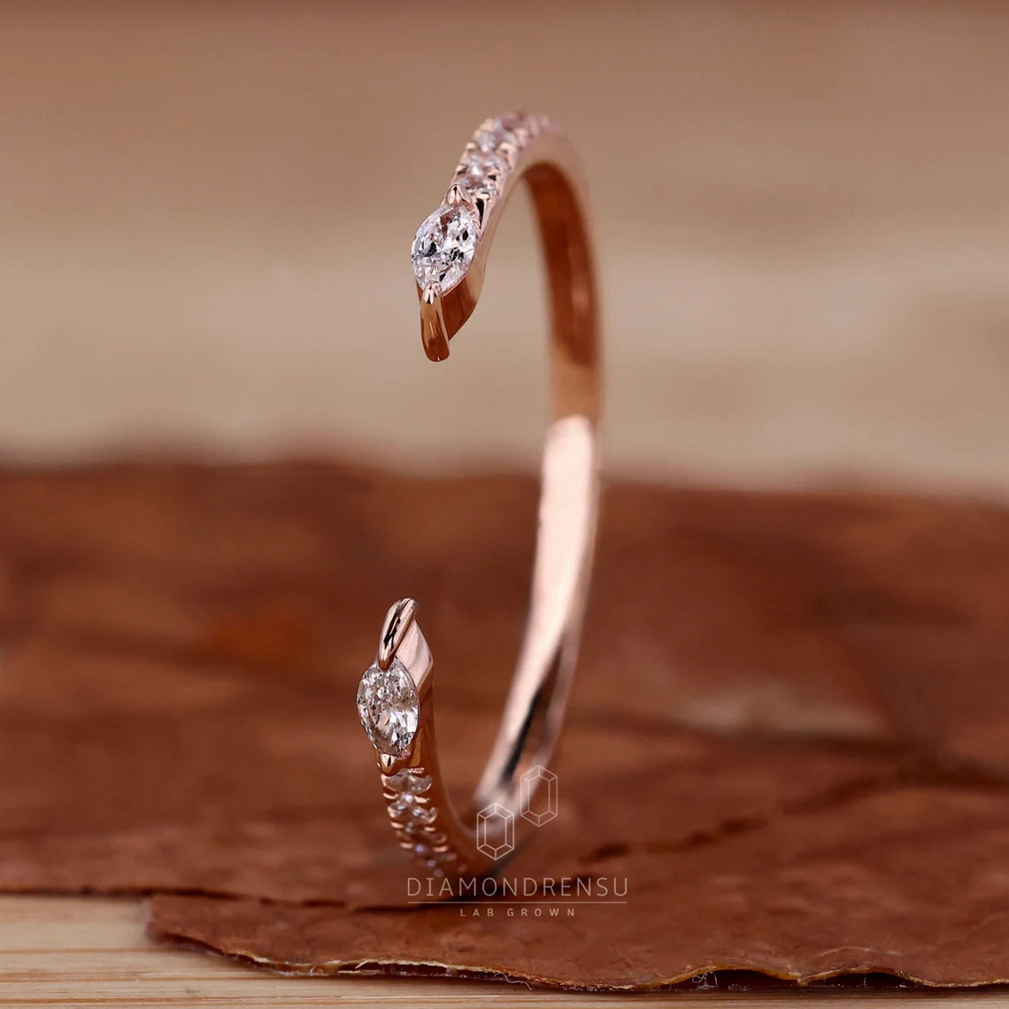 Rose gold bracelet with diamonds on a brown textured surface