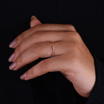 Hand wearing a thin ring on a black background