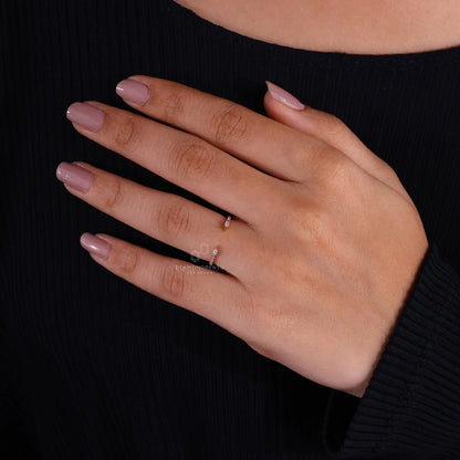 Hand wearing a ring with a clear stone against a black background