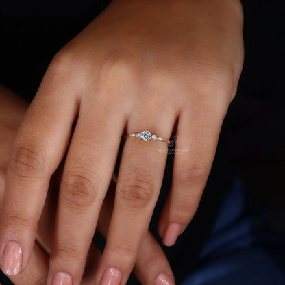 Close-up of a hand wearing a diamond ring on a dark background