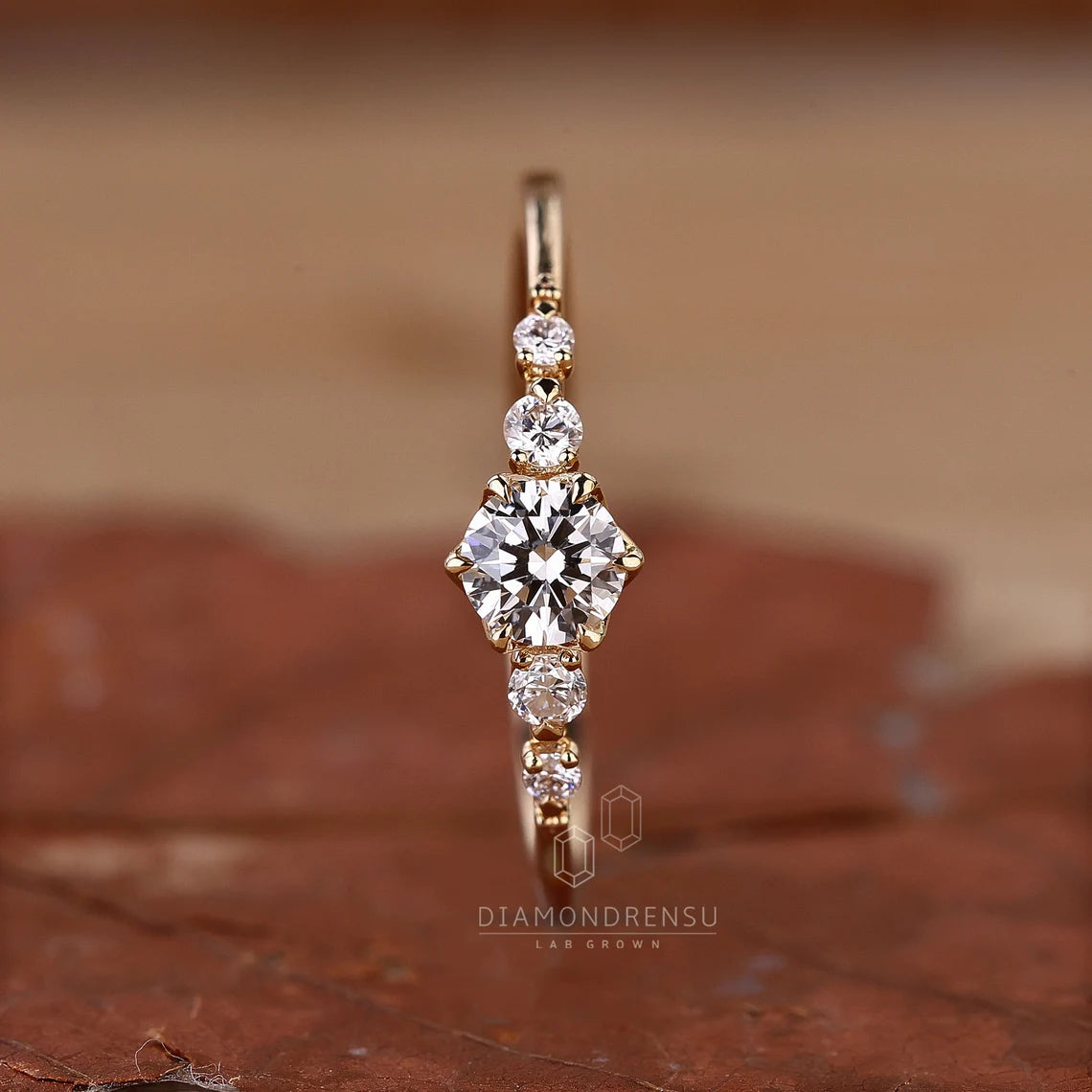 Gold ring with diamonds on a brown surface
