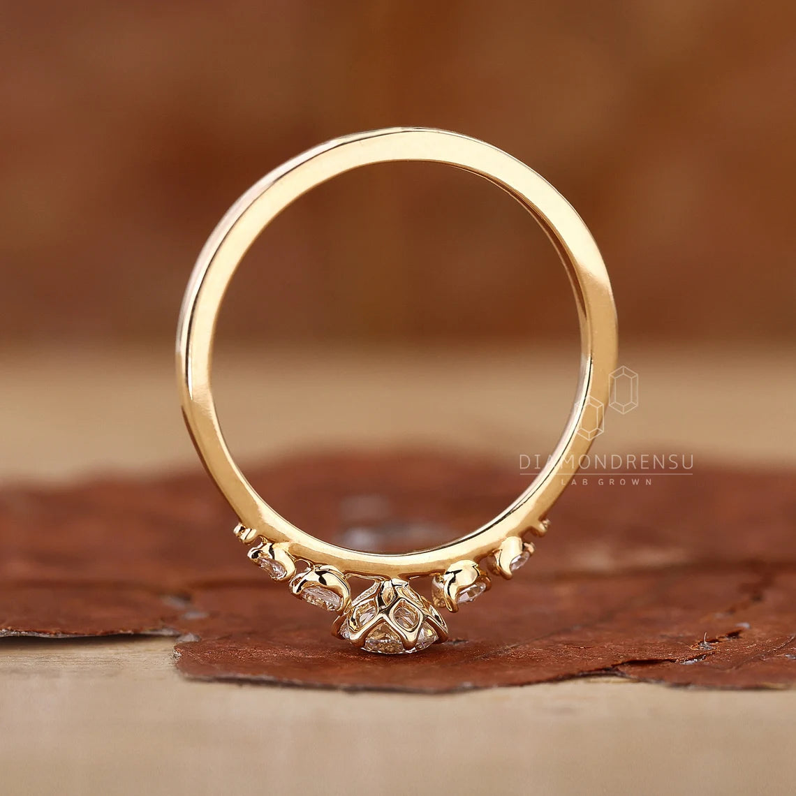 Gold ring with intricate design on a brown surface