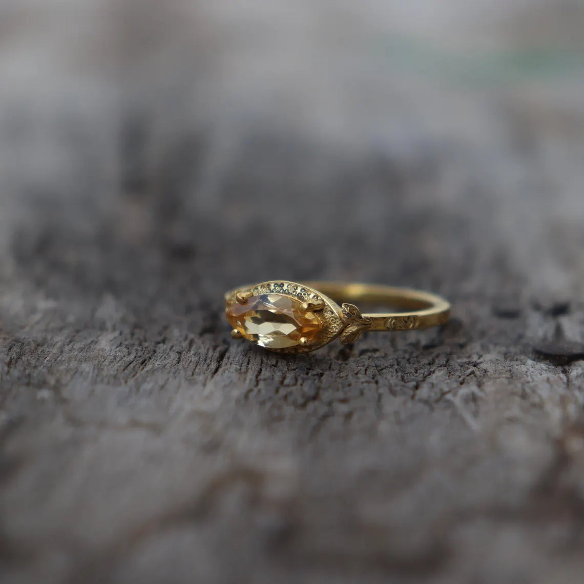 Gold ring with a large gemstone on a textured surface