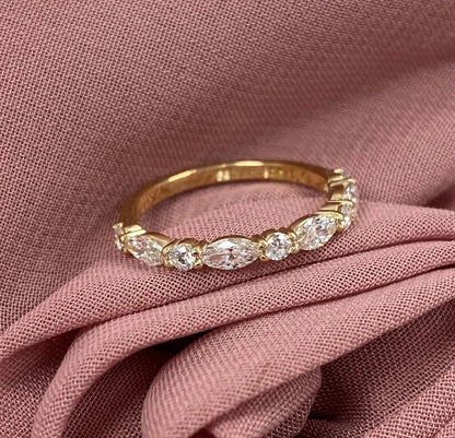 Gold ring with diamonds on a pink fabric background