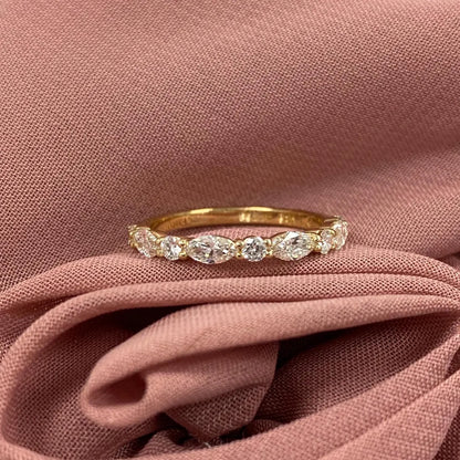 Gold ring with diamonds on a pink fabric background