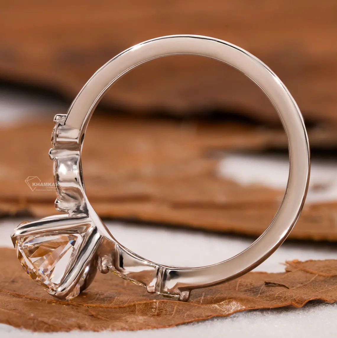 Silver ring with a large diamond on a wooden surface