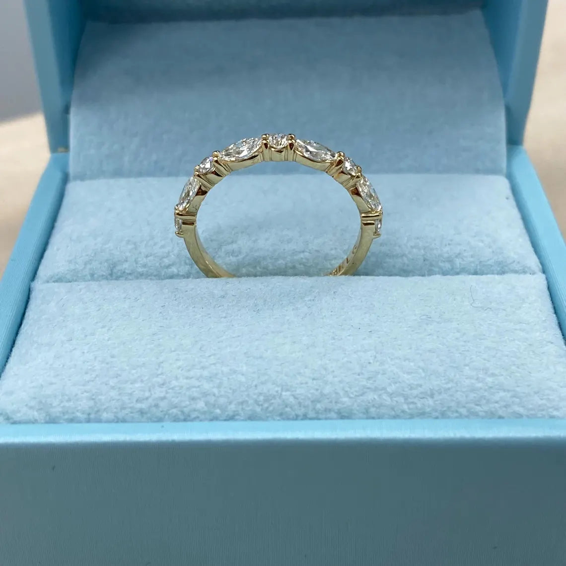 Gold ring with diamonds in a blue jewelry box