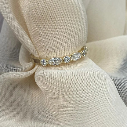 Gold ring with diamonds on a beige fabric background