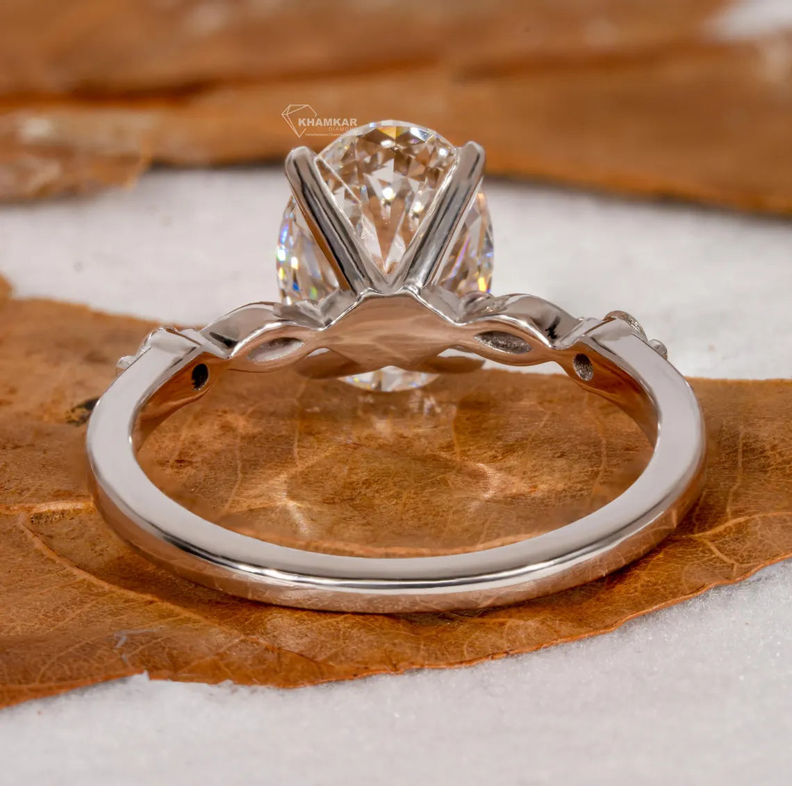 Silver ring with a diamond on a brown leaf