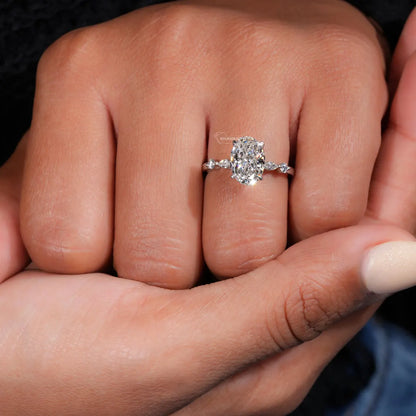Close-up of a hand wearing a diamond ring with a dark background
