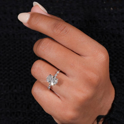 Close-up of a hand wearing a diamond ring on a black textured background