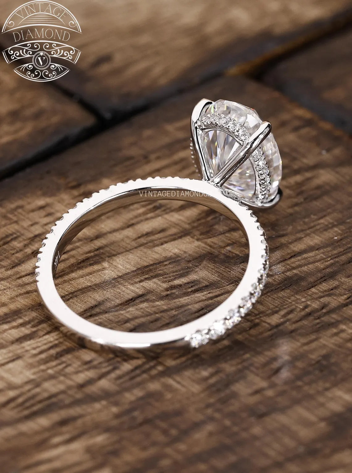 Silver ring with diamond on a wooden surface, featuring Vintage Diamond logo.