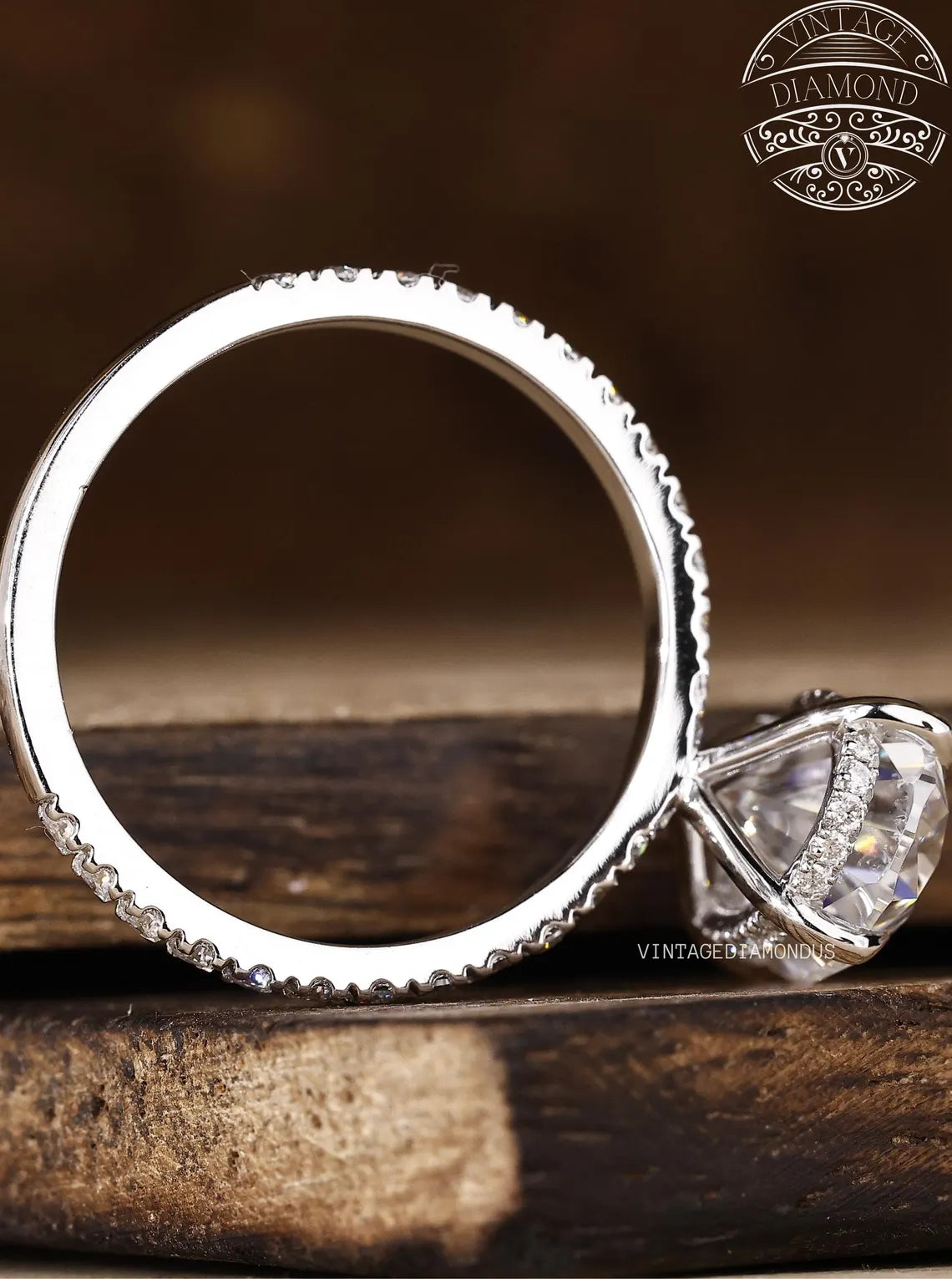 Silver ring with diamond on a wooden surface, featuring Vintage Diamond logo.