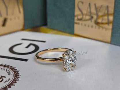 Gold ring with a large diamond on a white surface with 'IGI' and 'SAYA' branding.