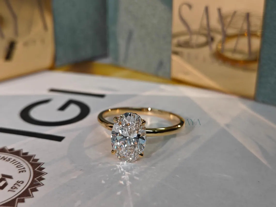 Gold ring with a diamond on a white surface with a blurred background