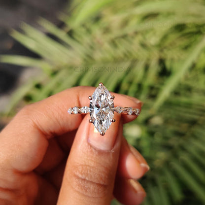 Diamond ring held in a hand with a blurred green background
