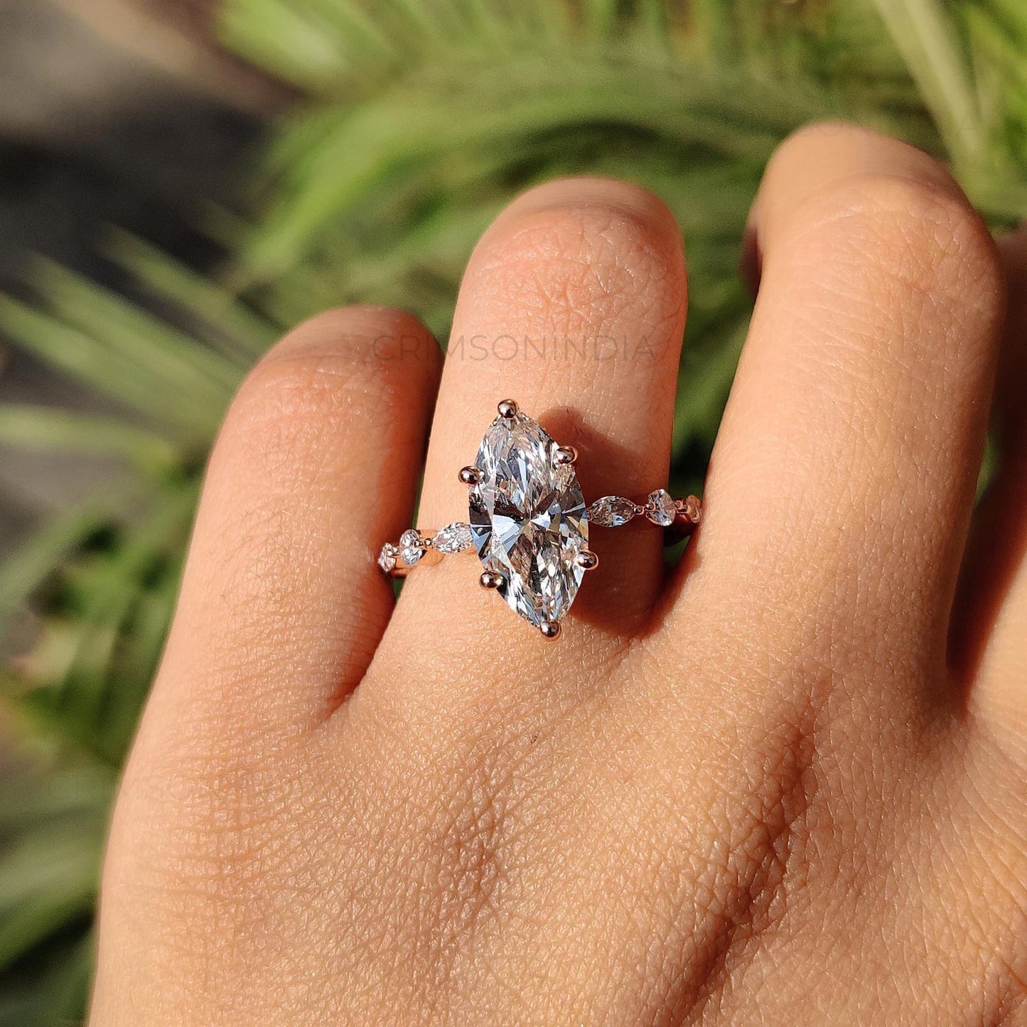 Diamond ring on a finger with a blurred natural background